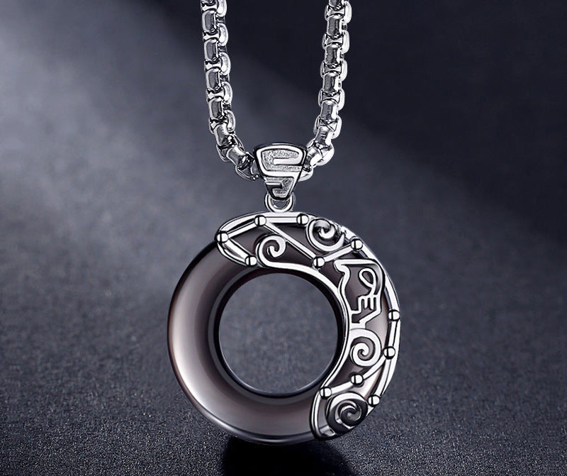 Silver pendant necklace on a dark background